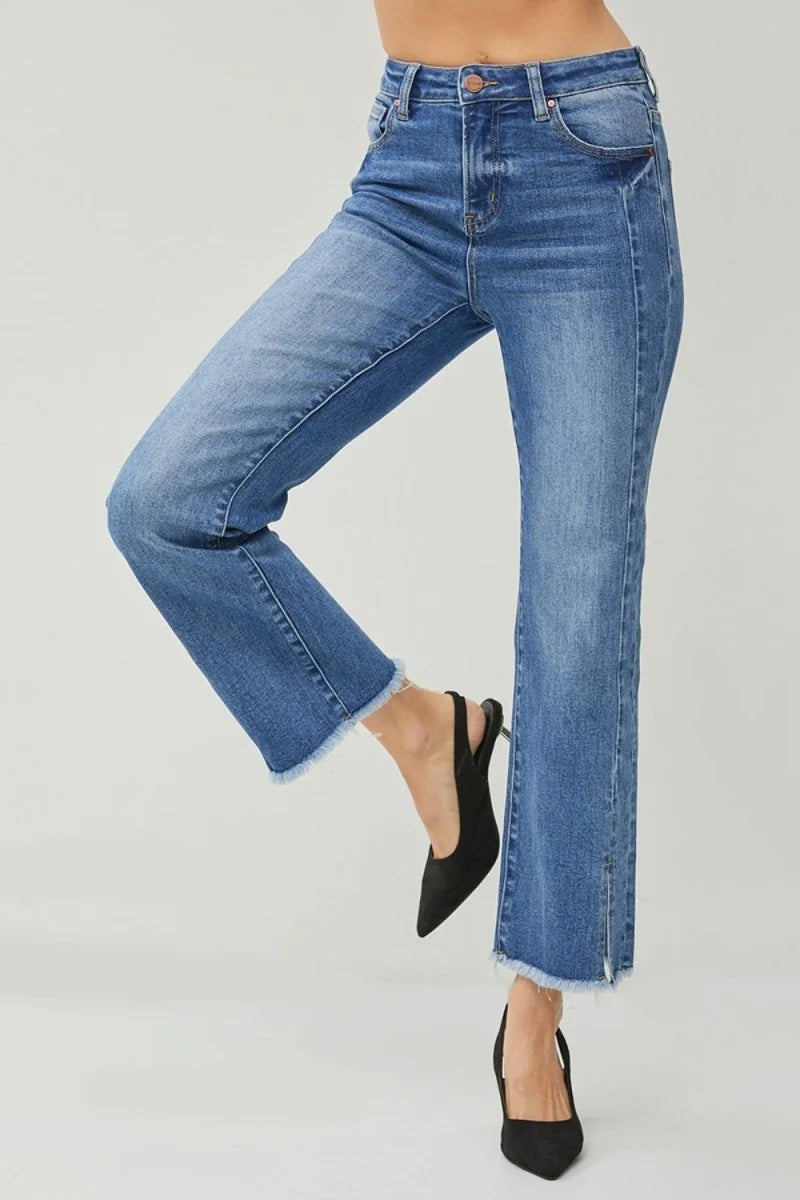 High-waisted blue denim jeans with a frayed hem and a subtle slit detail at the ankle.