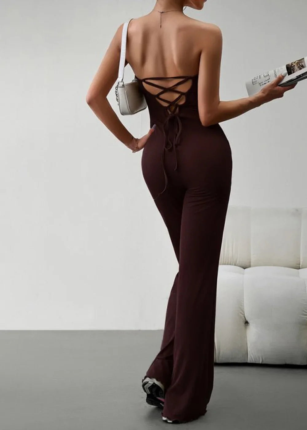 Brown strapless jumpsuit with lace-up back detail and flared legs, worn by a model.