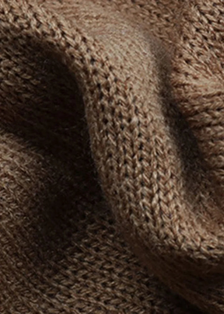 Close-up of a brown knit sweater dress fabric with a soft, textured weave.