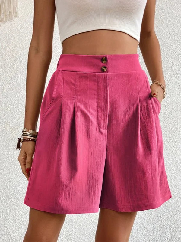 Bright pink textured shorts with a high waist and button detail, shown on a model.