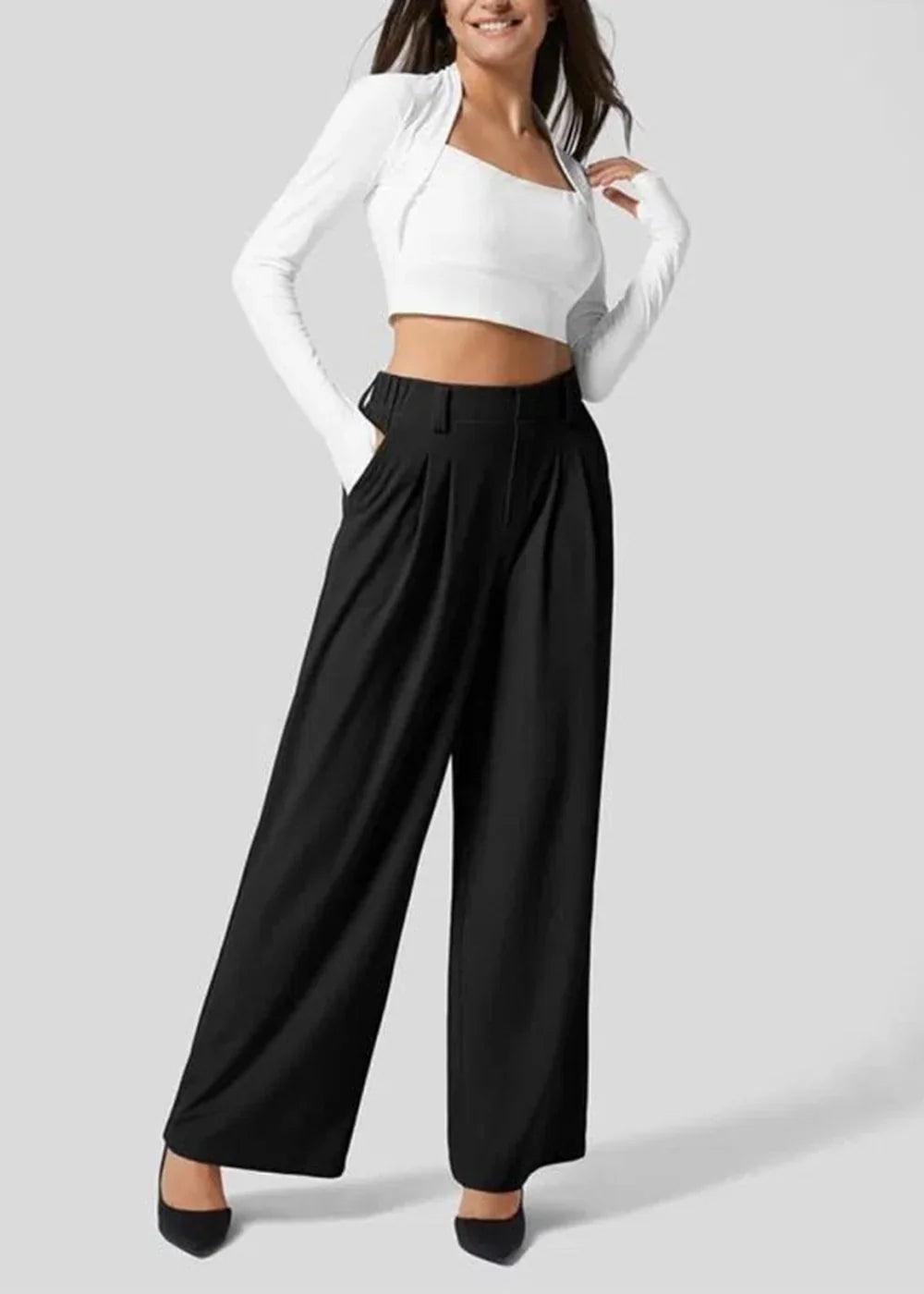 Black wide-leg pleated pants with a high waist, worn by a model with a white crop top and bolero.