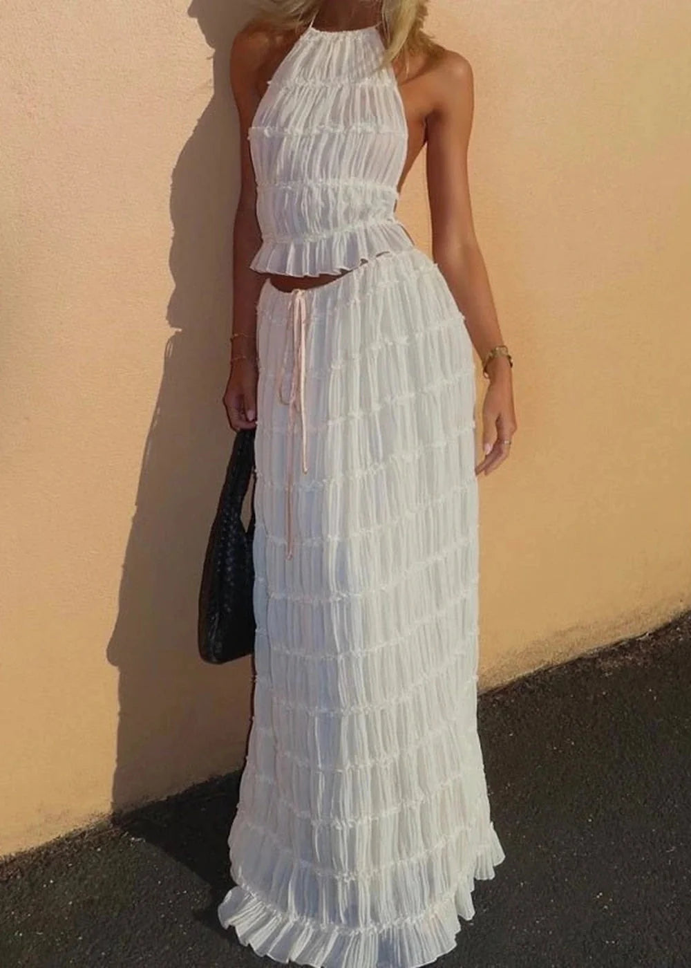 White ruched halter top and maxi skirt set with ruffle trim, on model.