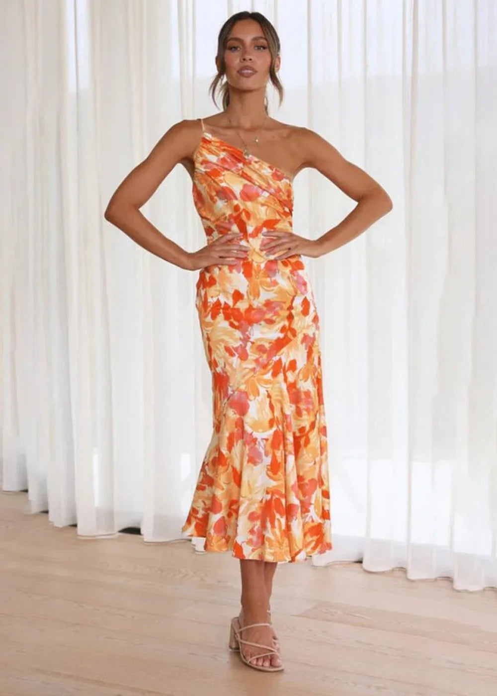 Full-length orange floral print dress with one-shoulder neckline on a model.