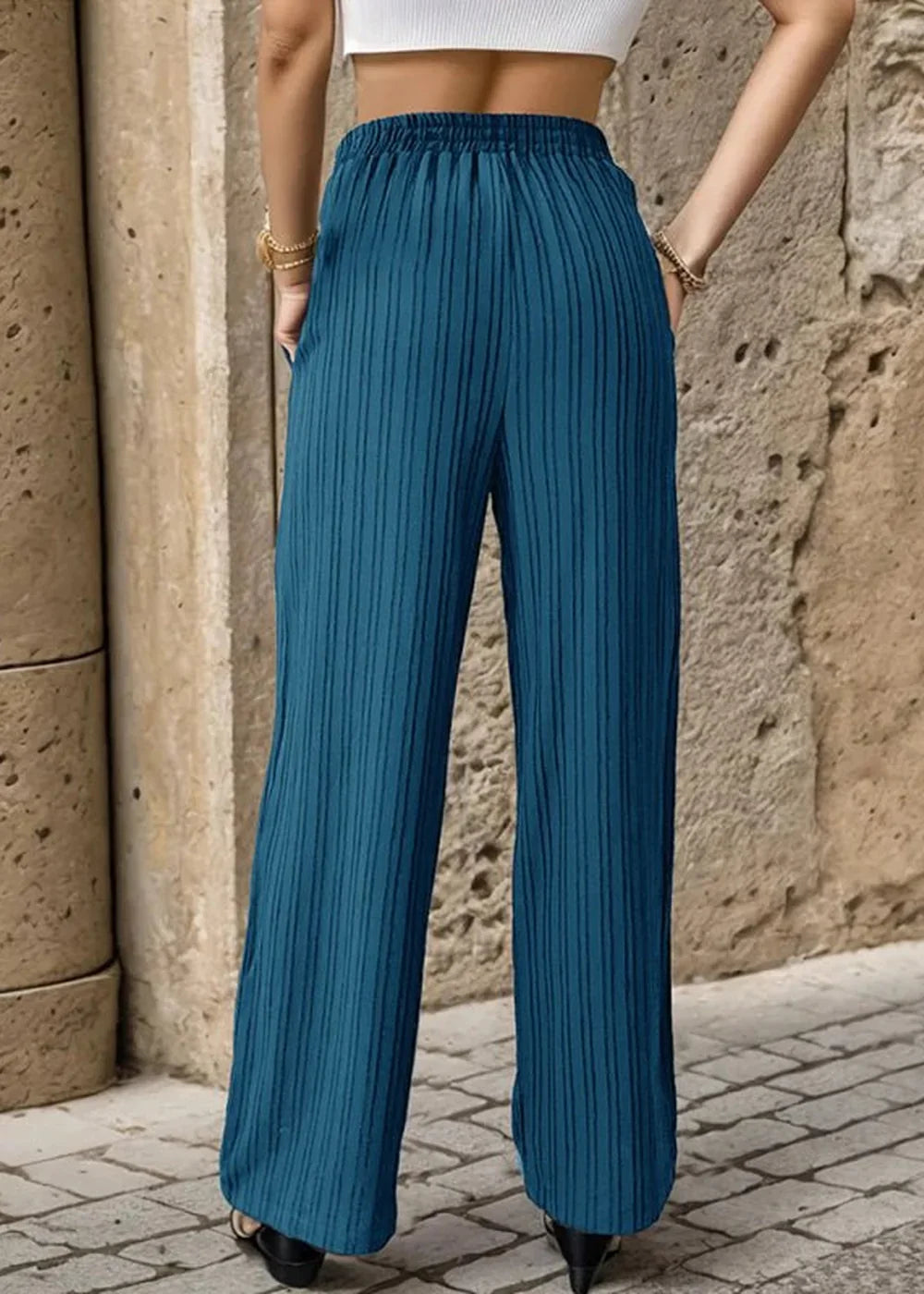 Teal pleated wide-leg pants with an elastic waistband, shown from the back.