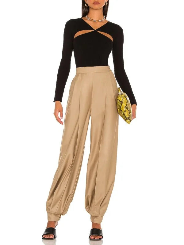 Black long-sleeve top with cutout detail and tan wide-leg pants on model.