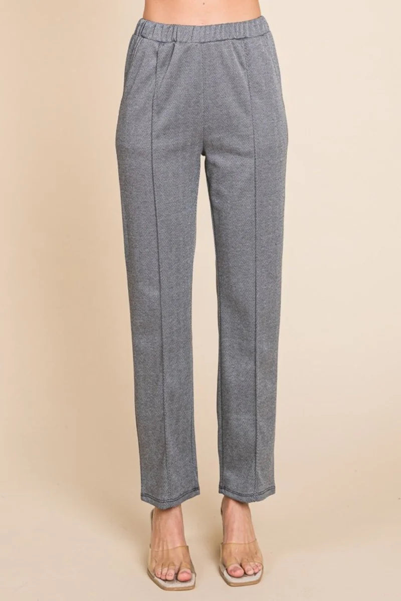 Gray herringbone patterned pants with a regular fit and subtle texture, shown on a model.