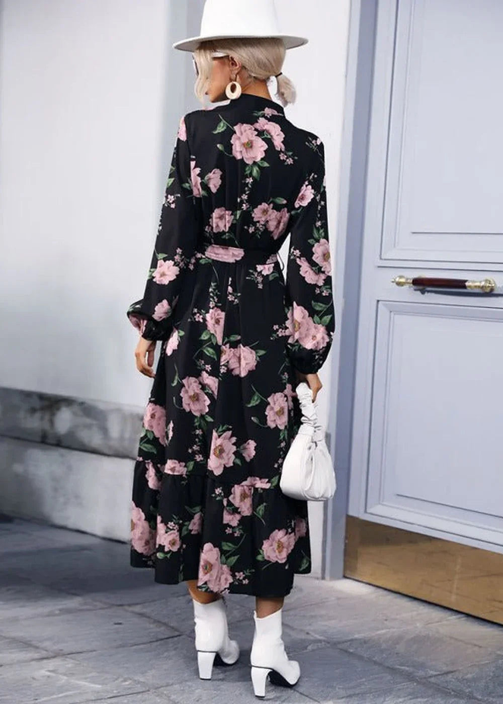 Black floral print dress with pink flowers, long sleeves, tiered skirt, and white boots.