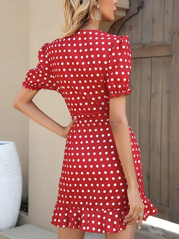 Red and white polka dot mini dress with ruffled sleeves and hem.