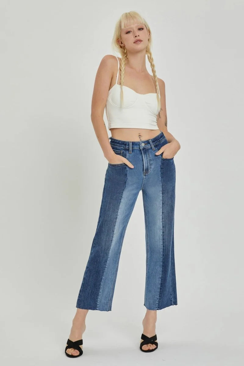 Cropped denim jeans with two-tone blue panels and frayed hem, on model.
