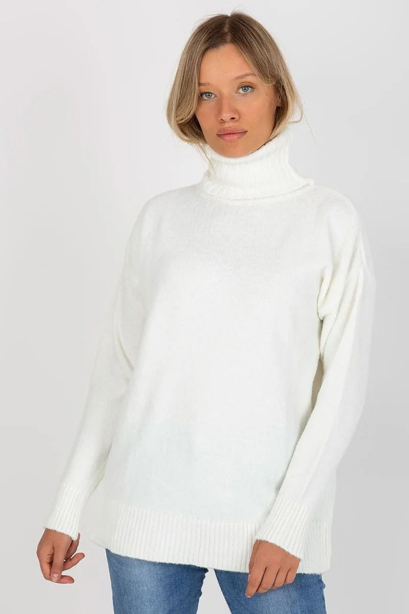 A woman wears a soft, white, fuzzy turtleneck sweater with a ribbed hem and cuffs, paired with blue jeans.