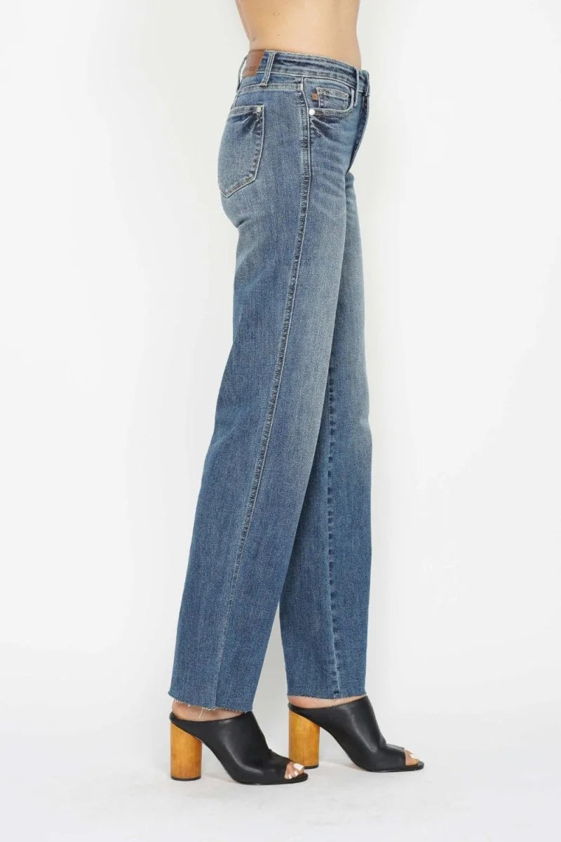 Blue denim straight-leg jeans with frayed hem and wooden-heeled black mules.