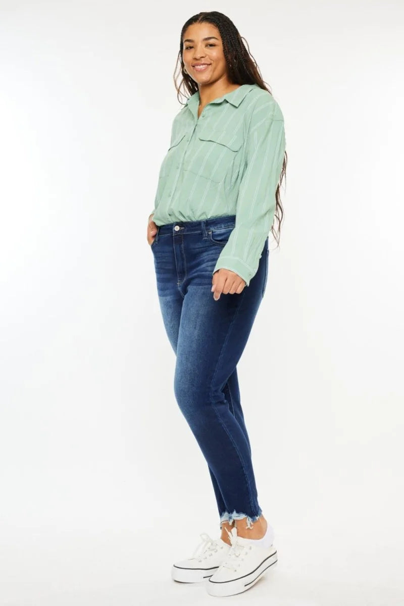 Dark wash denim jeans with a frayed hem on a model.