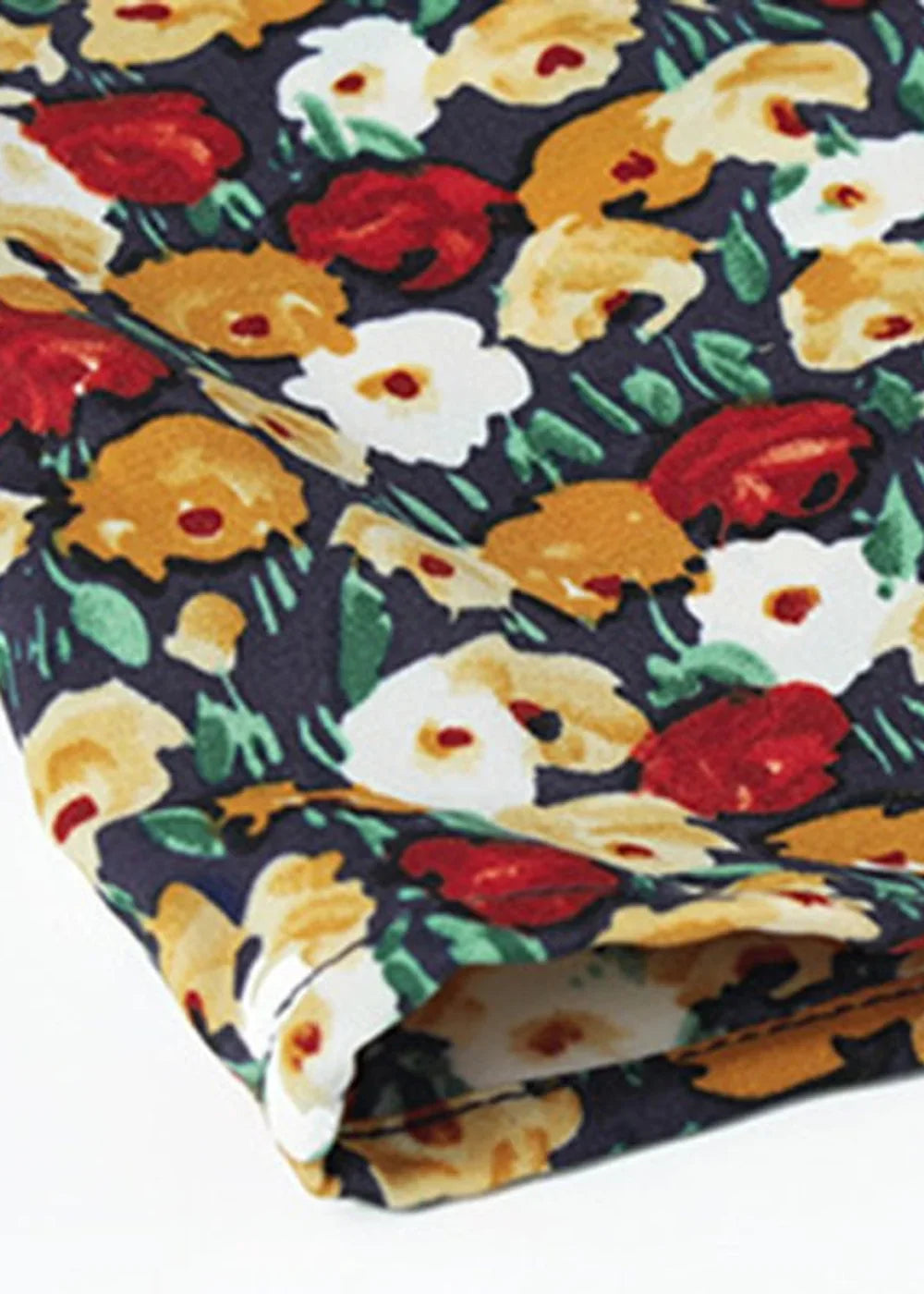 Close-up of a navy blue fabric with a bold floral print in red, yellow, and white, showing texture.