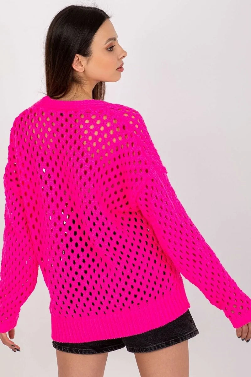 Bright pink open-knit sweater with long sleeves on a model.