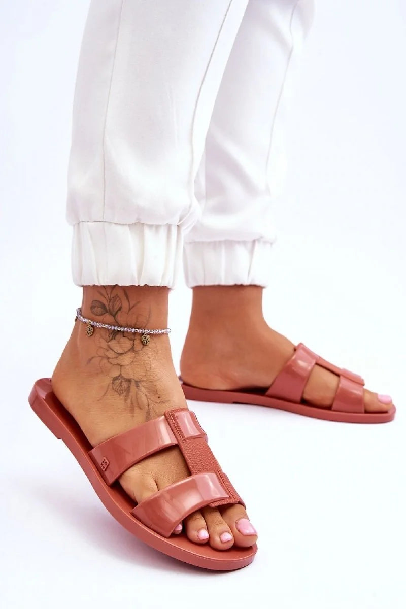 Rose pink slide sandals with double strap detail on a model's feet with an anklet.