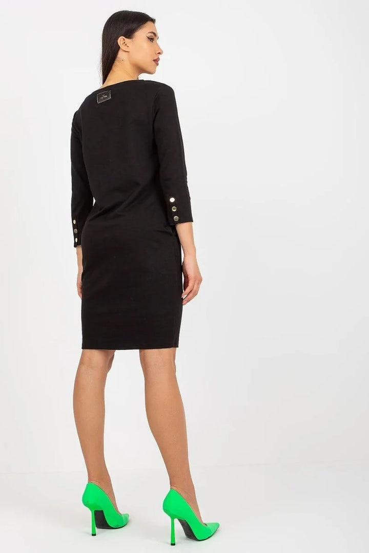 Black cotton-blend knee-length dress with gold button cuff details, worn with neon green heels.