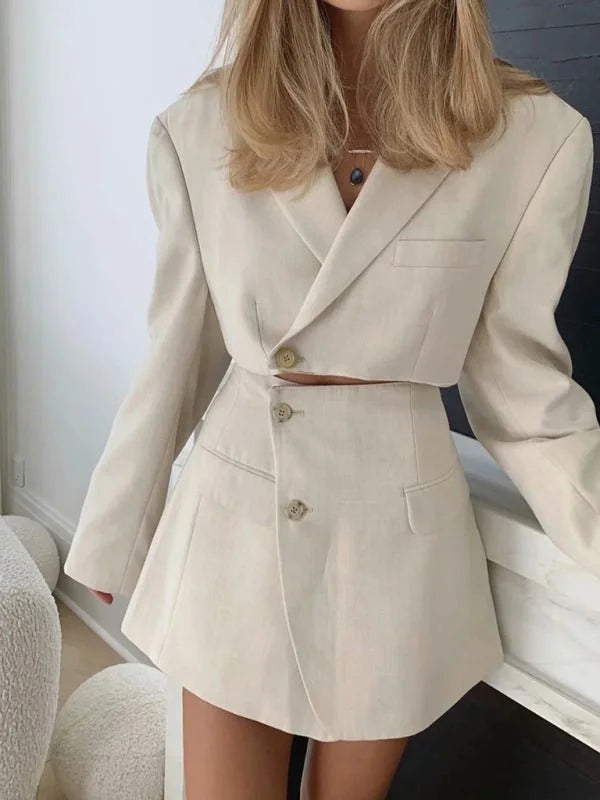 Cream linen-blend cropped blazer with matching high-waisted mini skirt on a model.