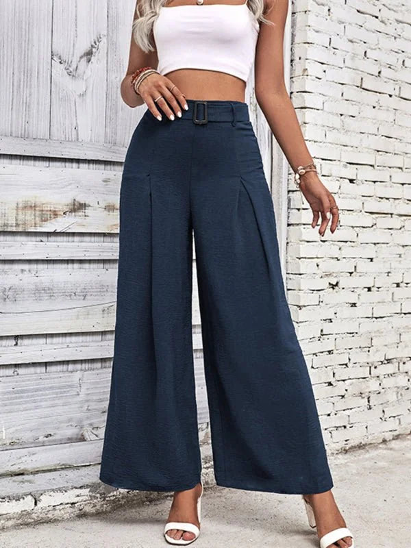 Navy blue textured wide-leg pants with a belted waist and pleats, on a model.