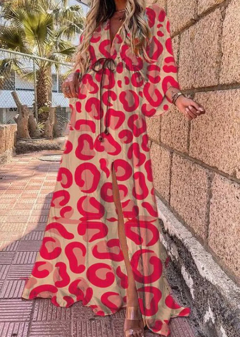 Flowy beige maxi dress with a bold red abstract leopard print and a high slit.