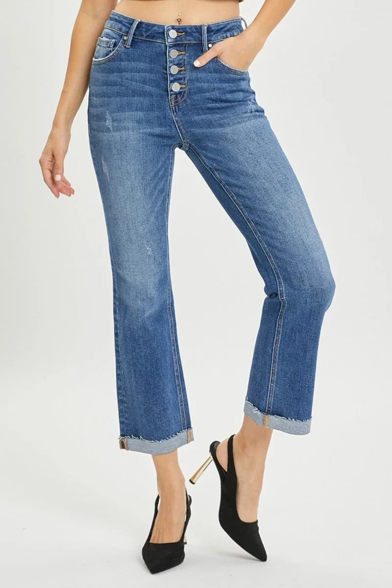 Medium wash denim jeans with a frayed hem and button fly, cropped at the ankle.