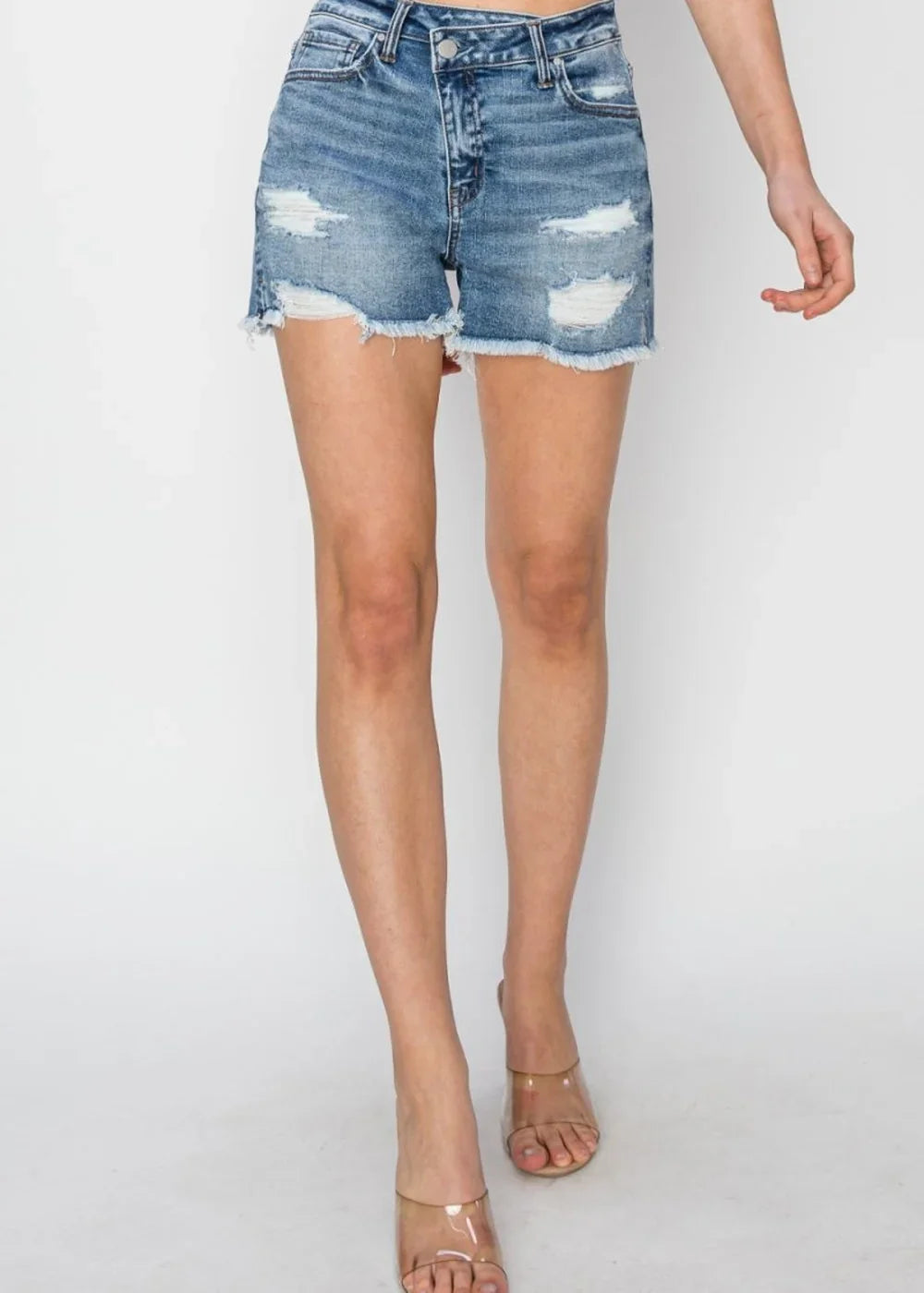 Distressed denim shorts with frayed hem and a regular fit, shown on a model.