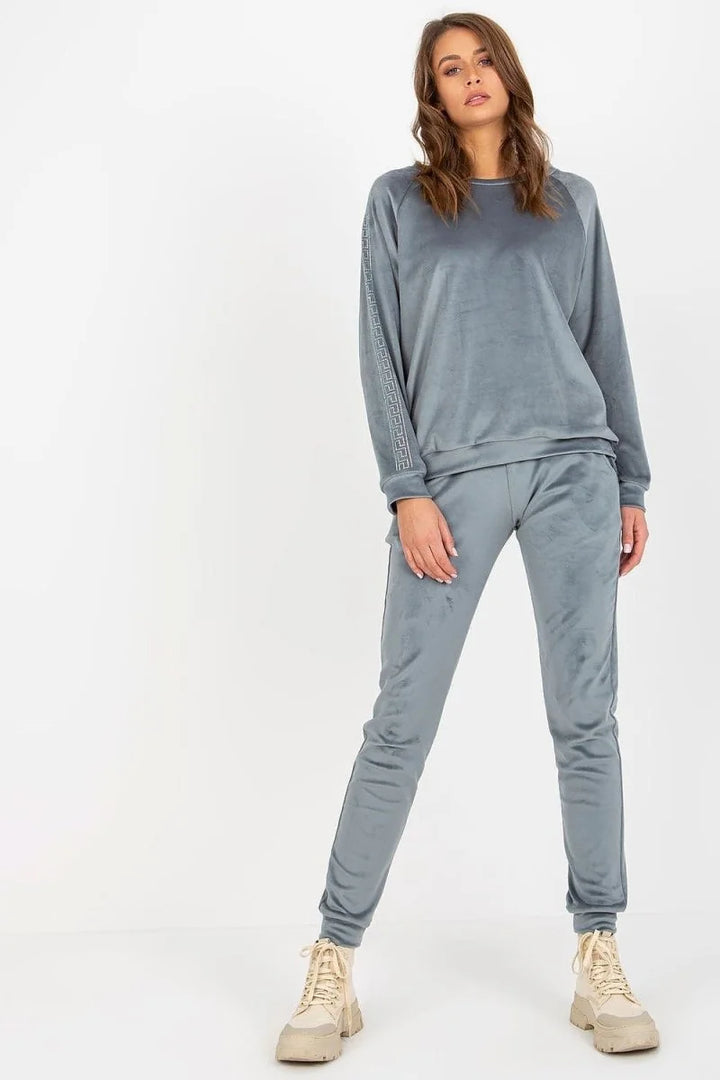Grey velvet tracksuit with geometric trim on sleeves and pants, on model.
