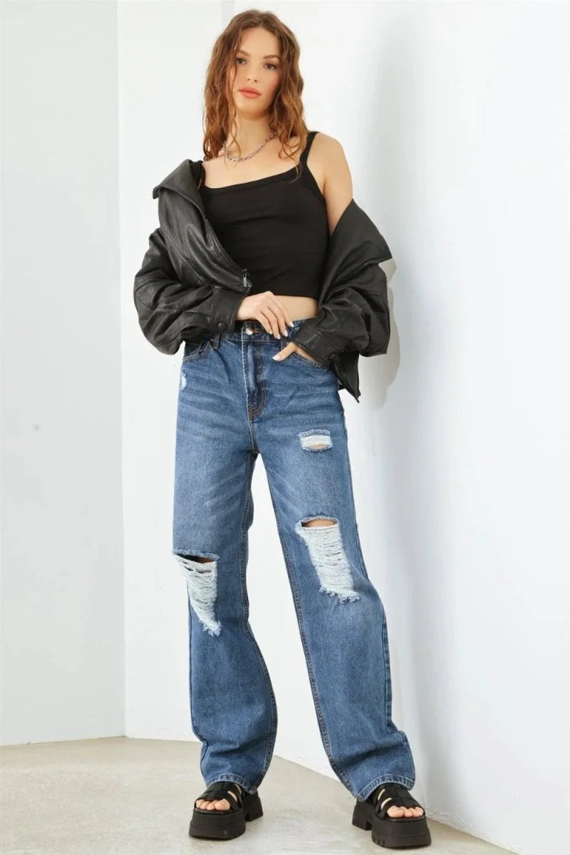 Distressed medium wash denim jeans with a wide leg fit and ripped details.