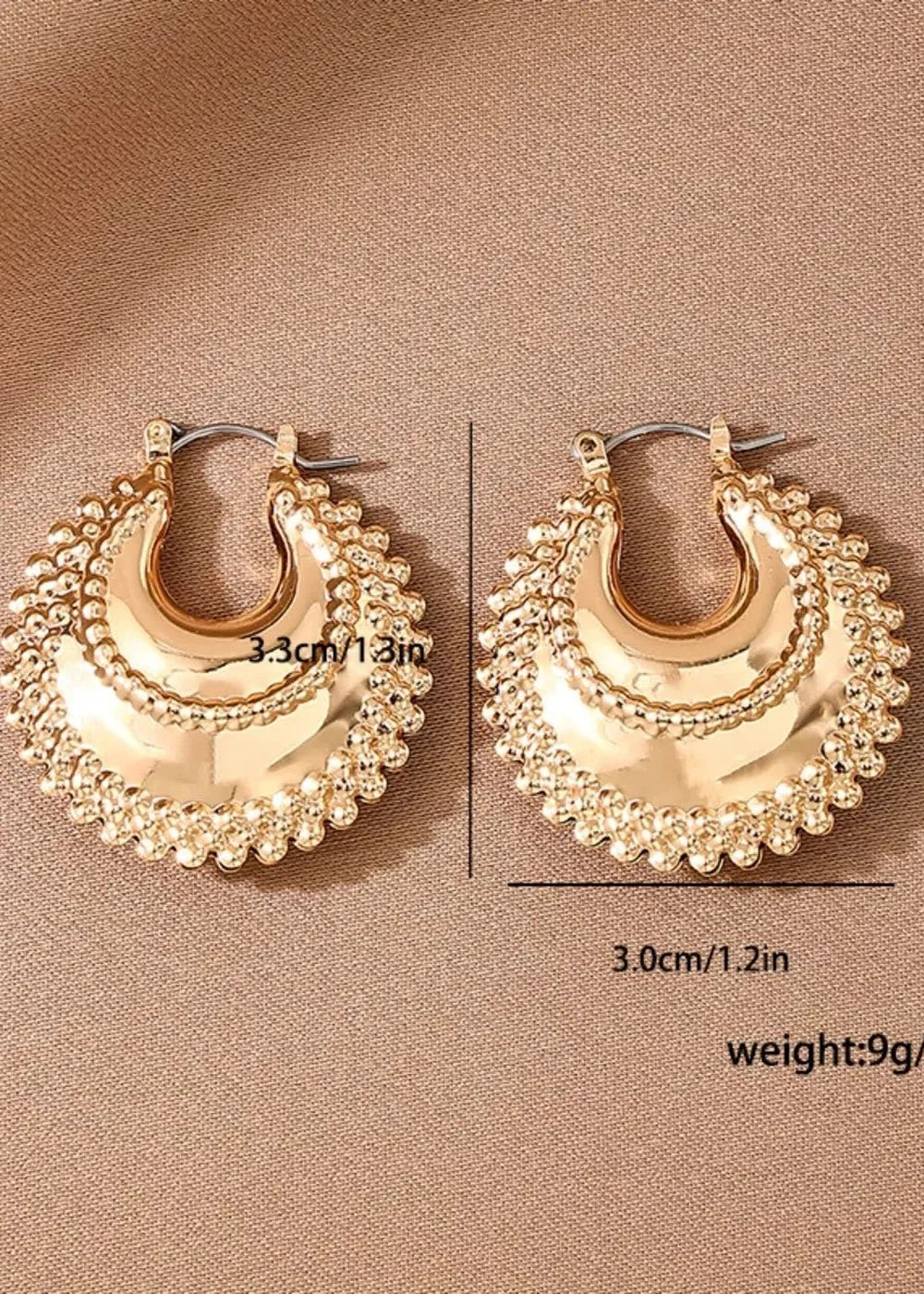 Gold hoop earrings with a textured, scalloped edge and a brushed metal finish.