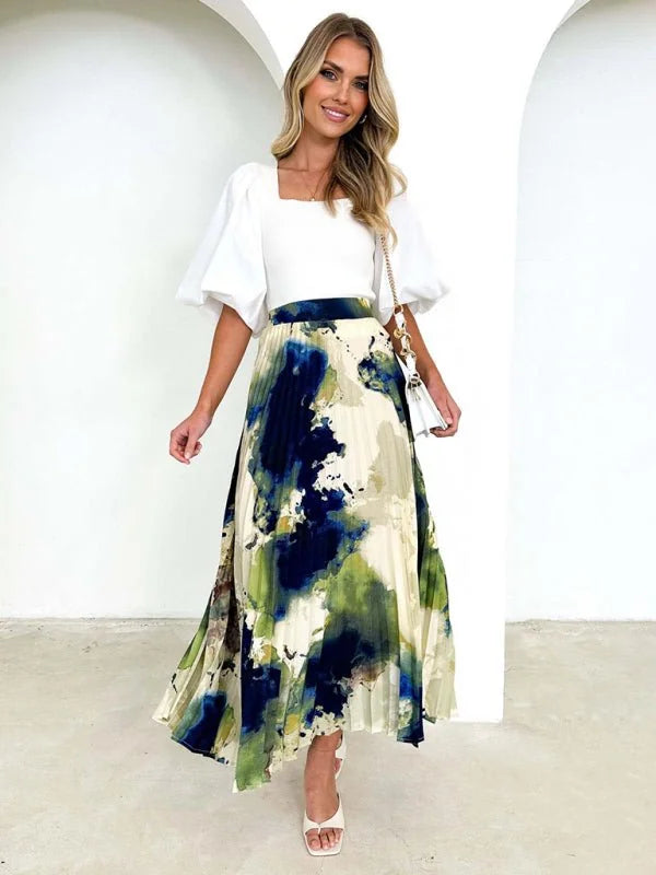 Cream pleated midi skirt with abstract navy blue and green watercolor print, on model.