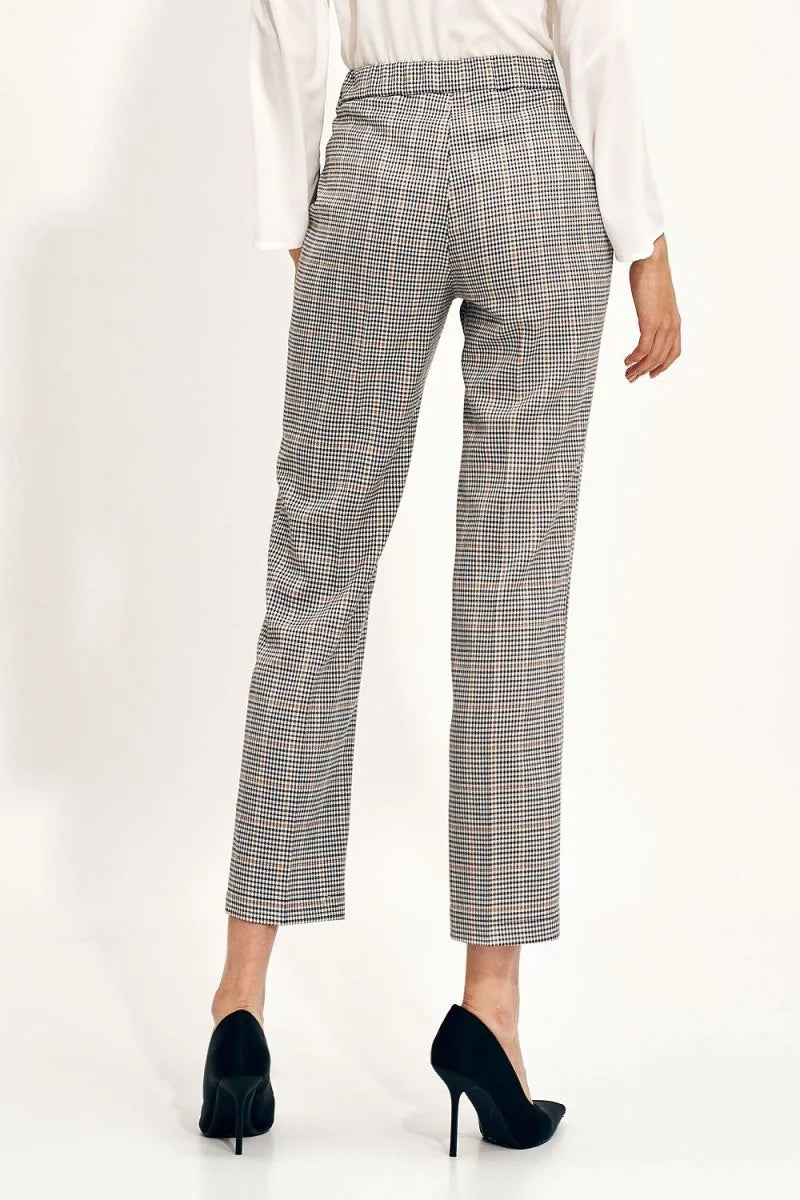 Woman's cropped plaid pants with a checkered pattern in brown, black, and white.