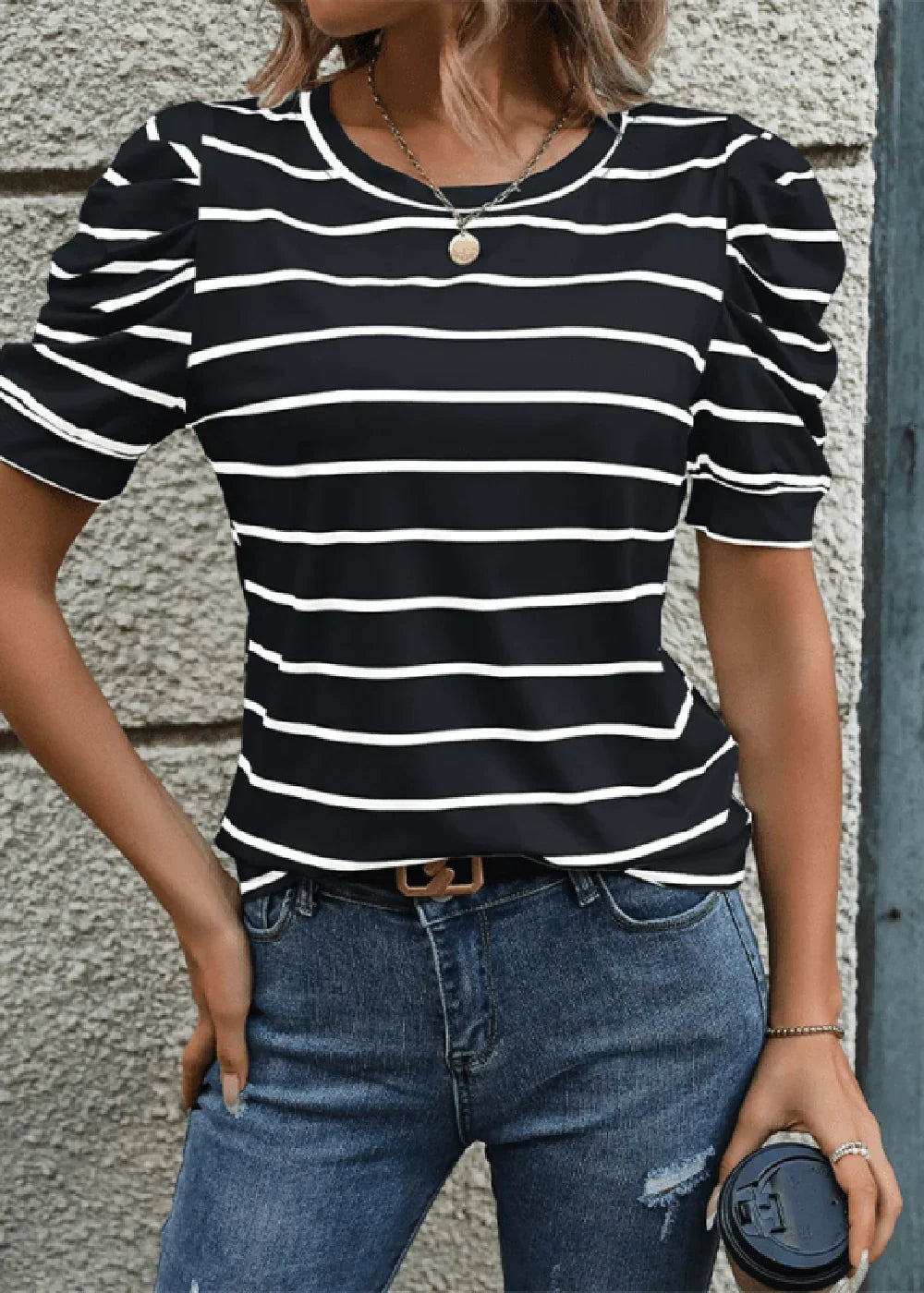 Black and white striped puff-sleeve top with a crew neck, paired with blue distressed jeans.
