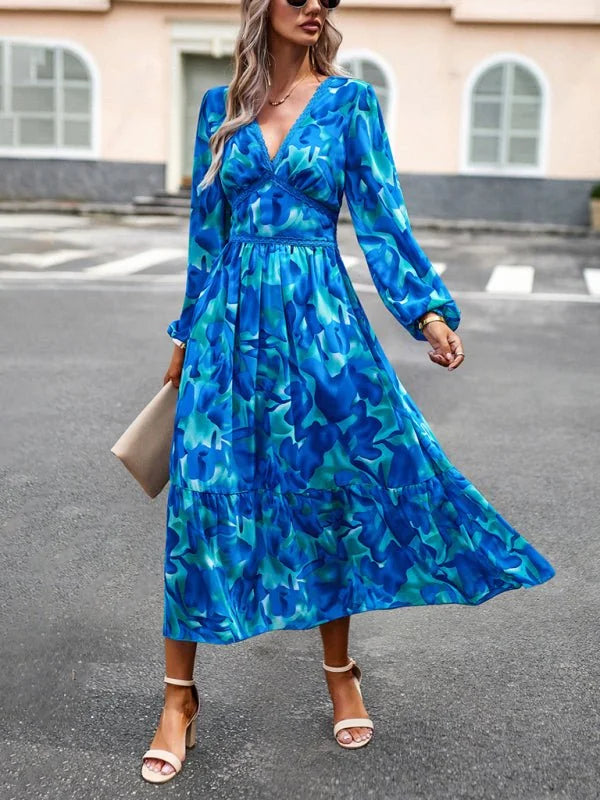 Blue and teal abstract floral print midi dress with V-neck and long sleeves.