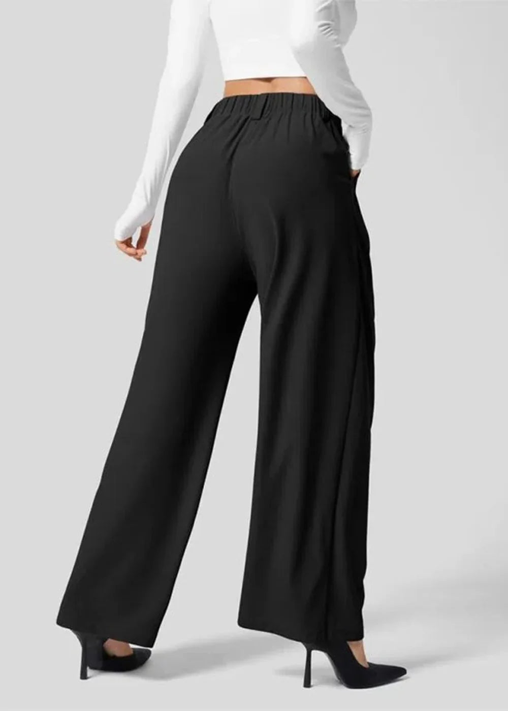 Black, wide-leg palazzo pants with a high waist and pockets, shown on a model wearing black heels.