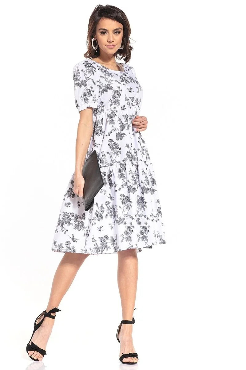 Relaxed fit cotton day dress with a black and white floral pattern, black bow sandals, and a black clutch.