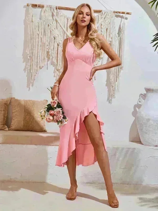 Pink V-neck midi dress with ruffle hem and thigh-high slit, on a model.