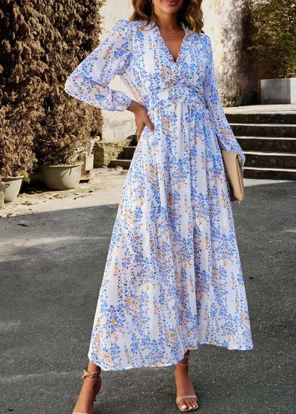 White maxi dress with blue and orange floral pattern, V-neck, and long sleeves.