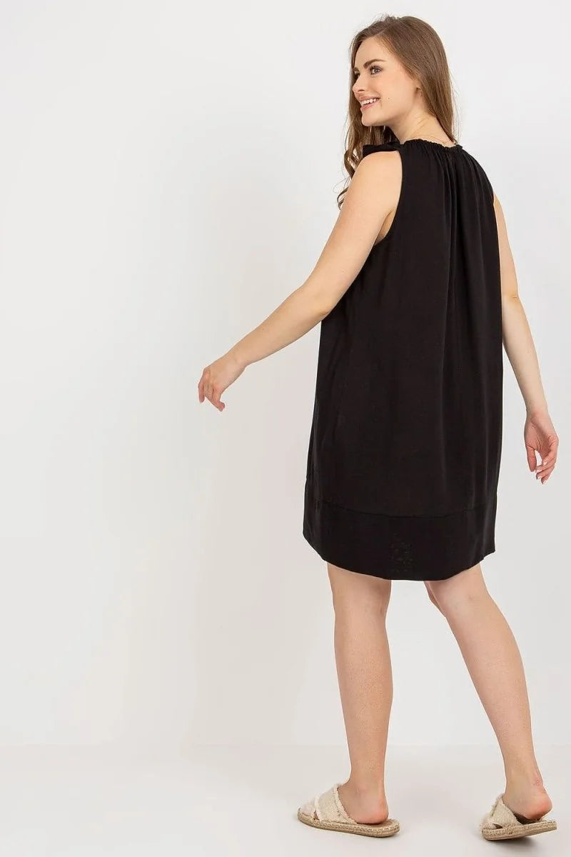 Loose-fit black viscose day dress with bow shoulder detail, shown from the back on a model.