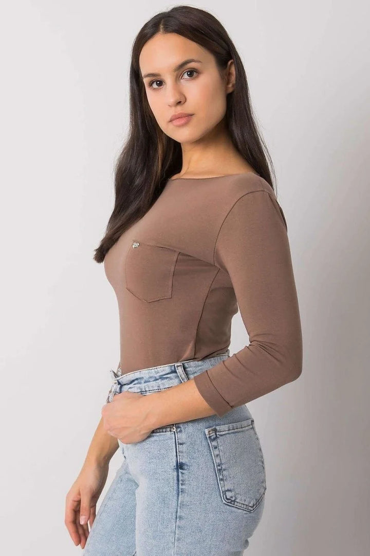 Brown long-sleeve shirt with chest pocket and light blue denim jeans.