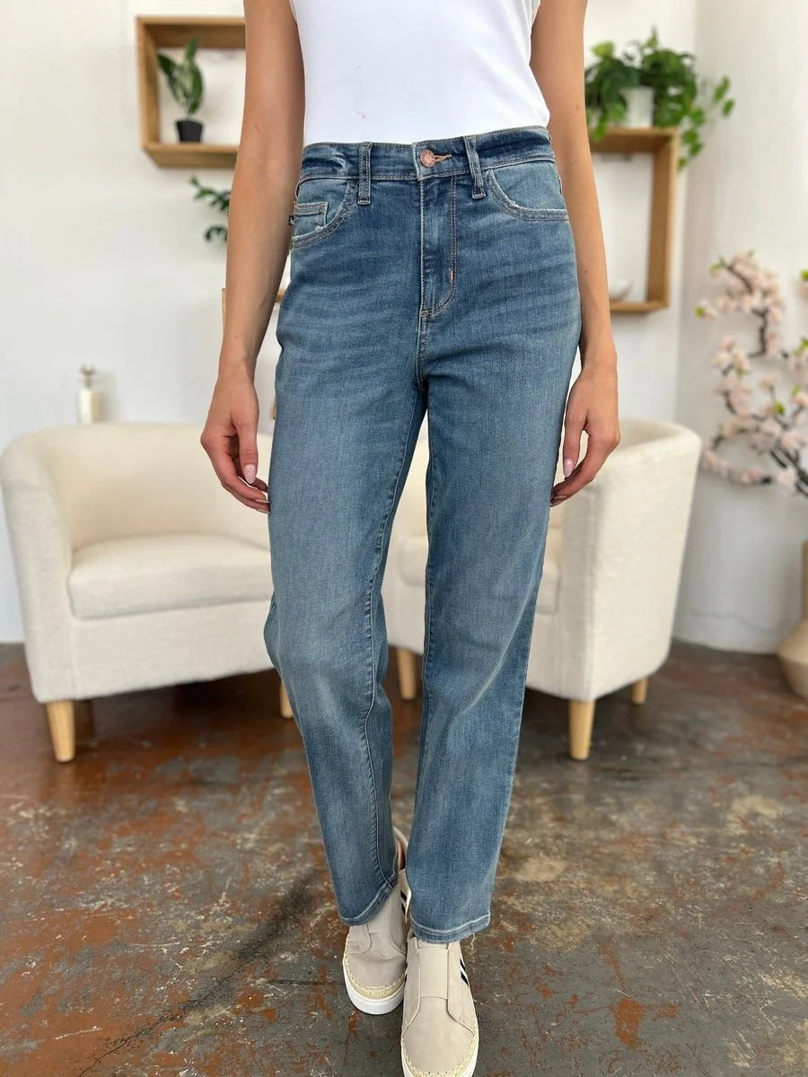 Blue denim jeans with moderate stretch, featuring a straight leg and subtle distressing.