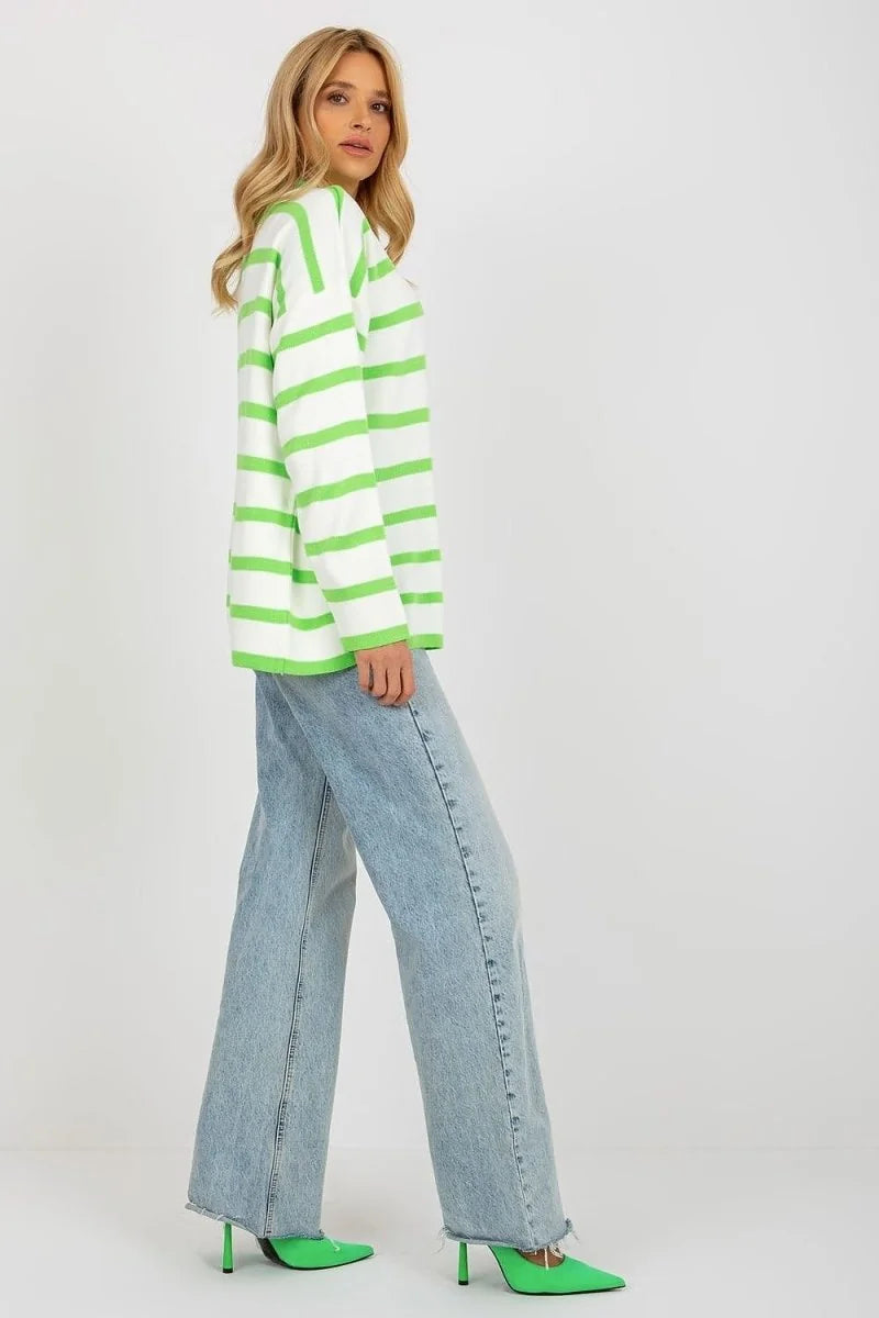 Relaxed fit white sweater with bright green stripes, paired with light wash wide-leg jeans and green pointed heels.