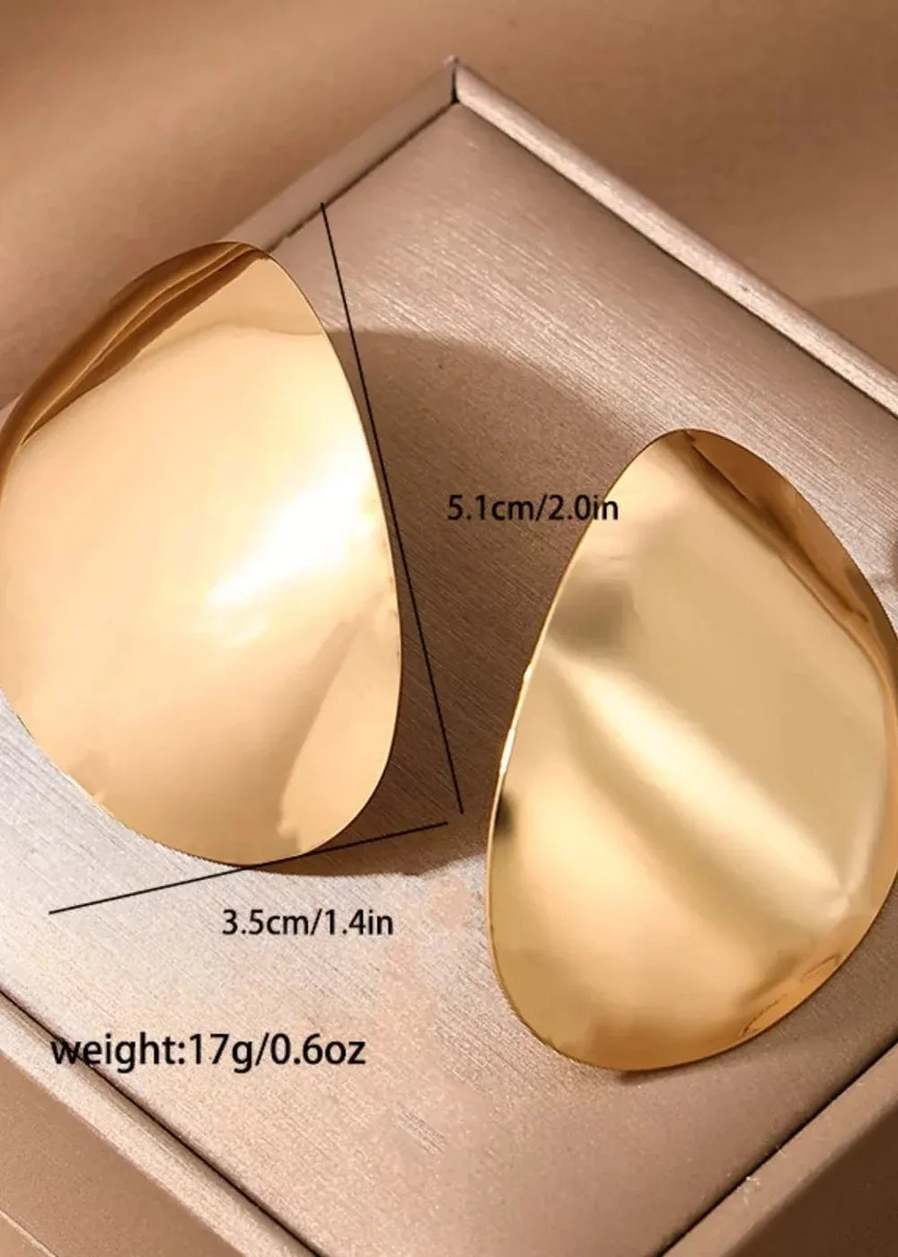 Golden, abstract-shaped earrings with a polished, reflective surface.