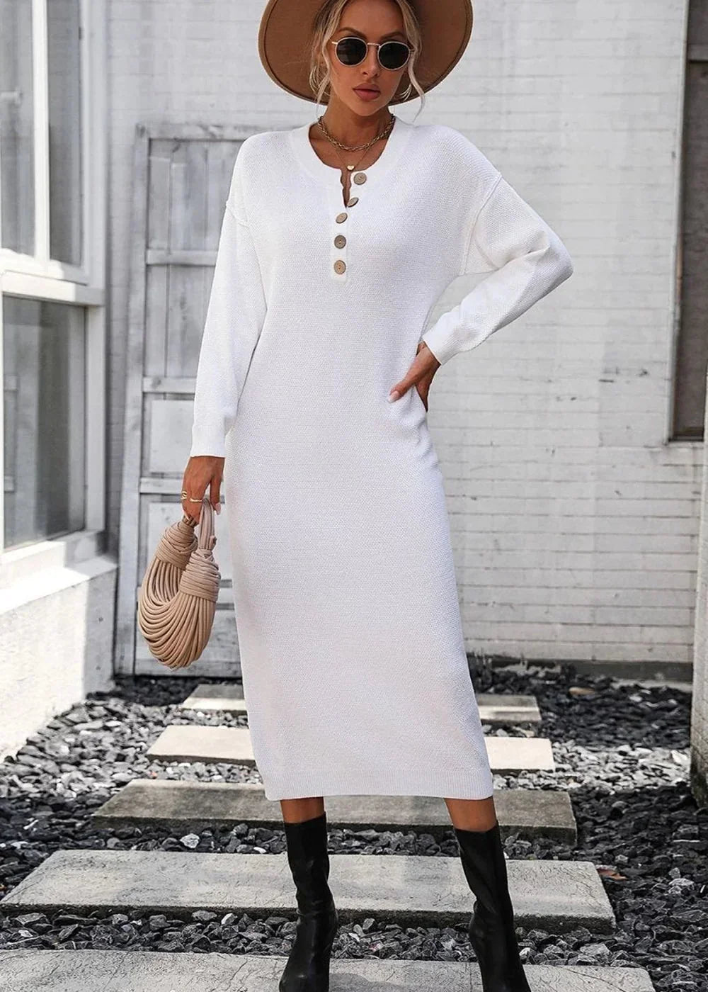 White knit sweater dress with button detail, worn by a model with a hat, sunglasses, and black boots.