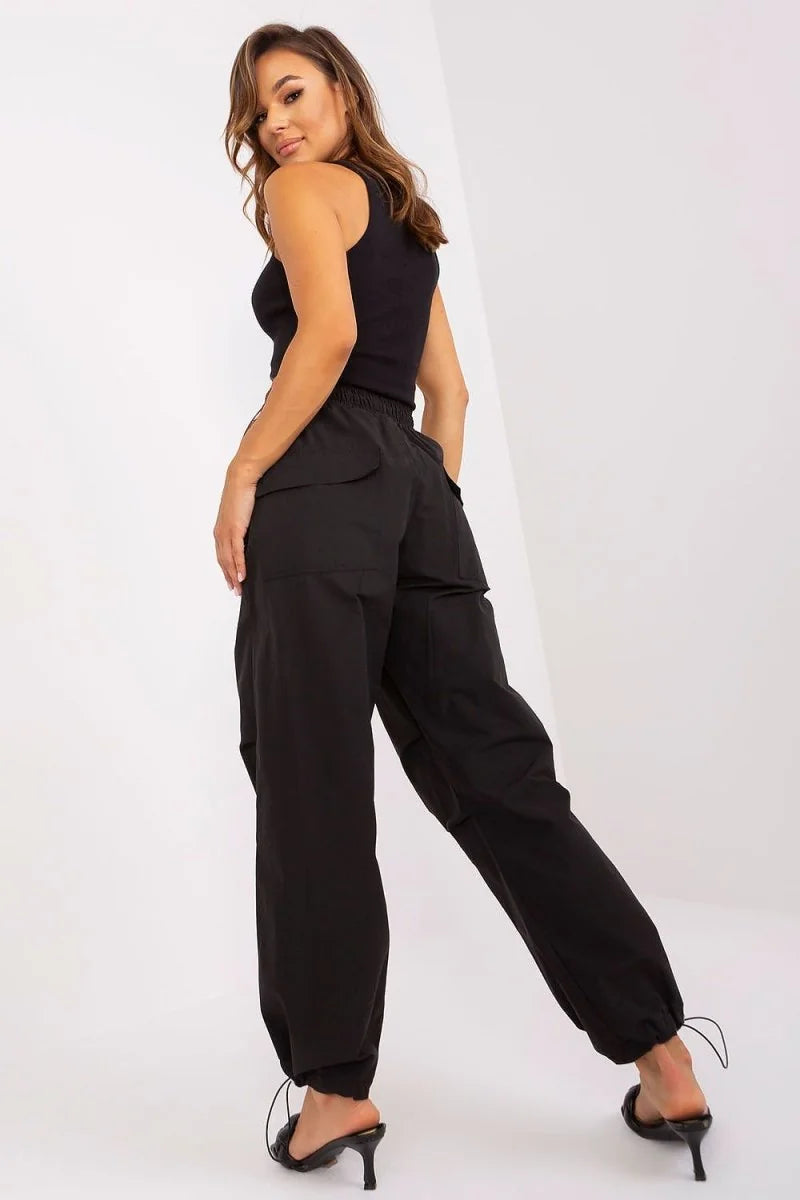 Black cargo pants with drawstring ankles and pockets, worn by a model.