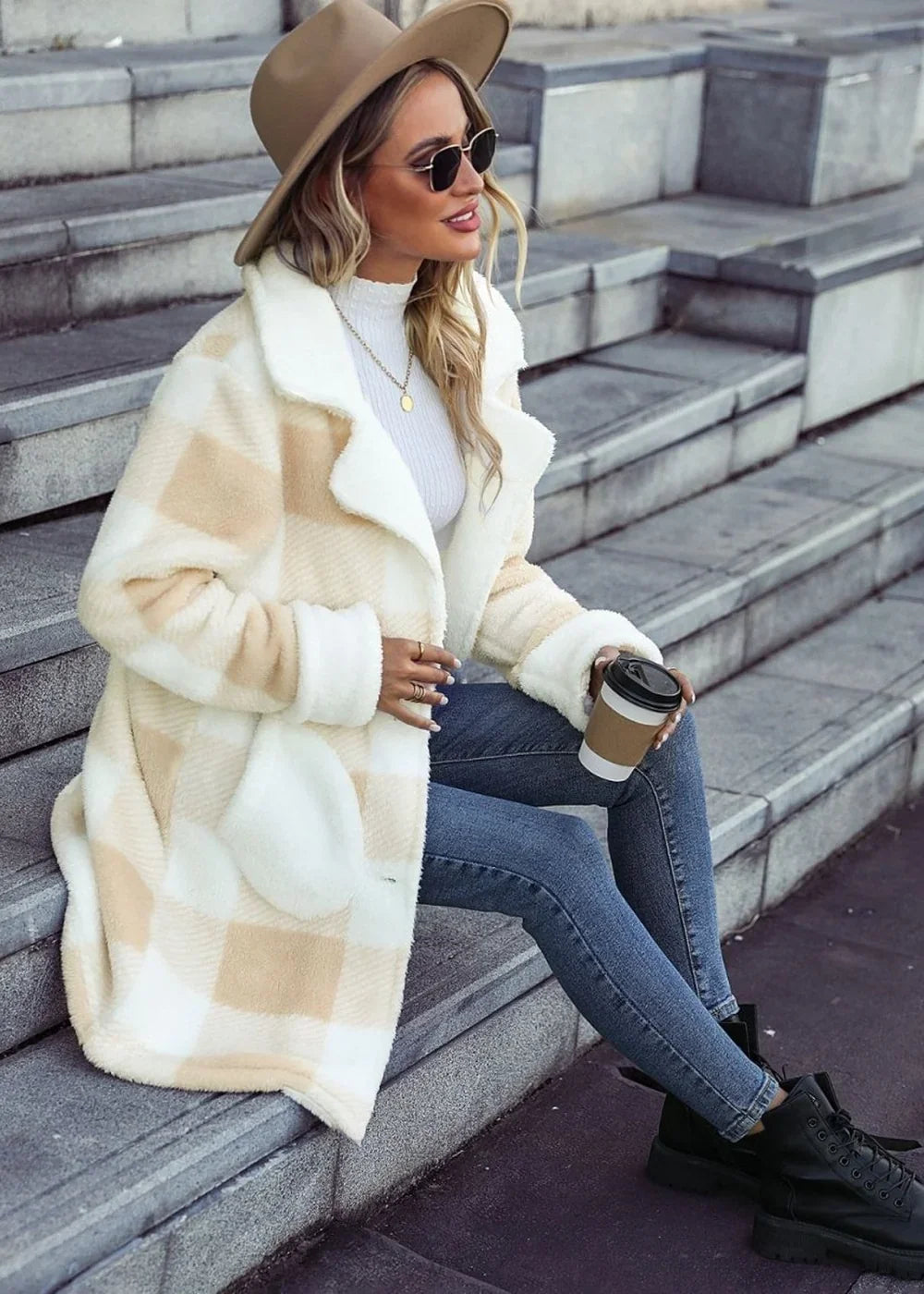 Cream and tan plaid plush coat with white trim on model, holding coffee cup.