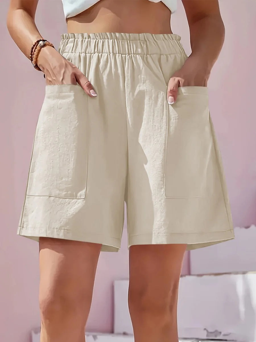 Light beige linen-blend shorts with elastic waistband and deep pockets, on model.