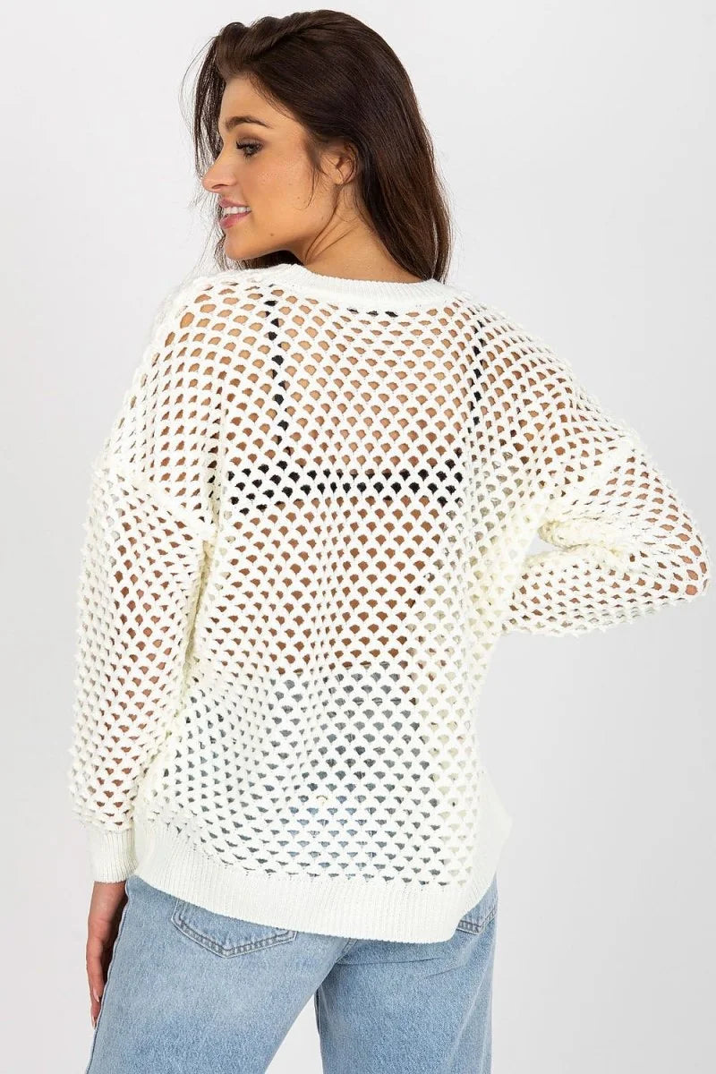 Back view of a woman wearing a white open-knit sweater over a black bra and light wash jeans.