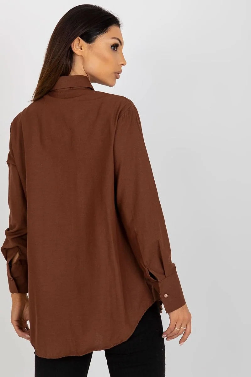 Model from the back in a loose-fit, long-sleeved brown cotton-blend shirt with cuffed sleeves.