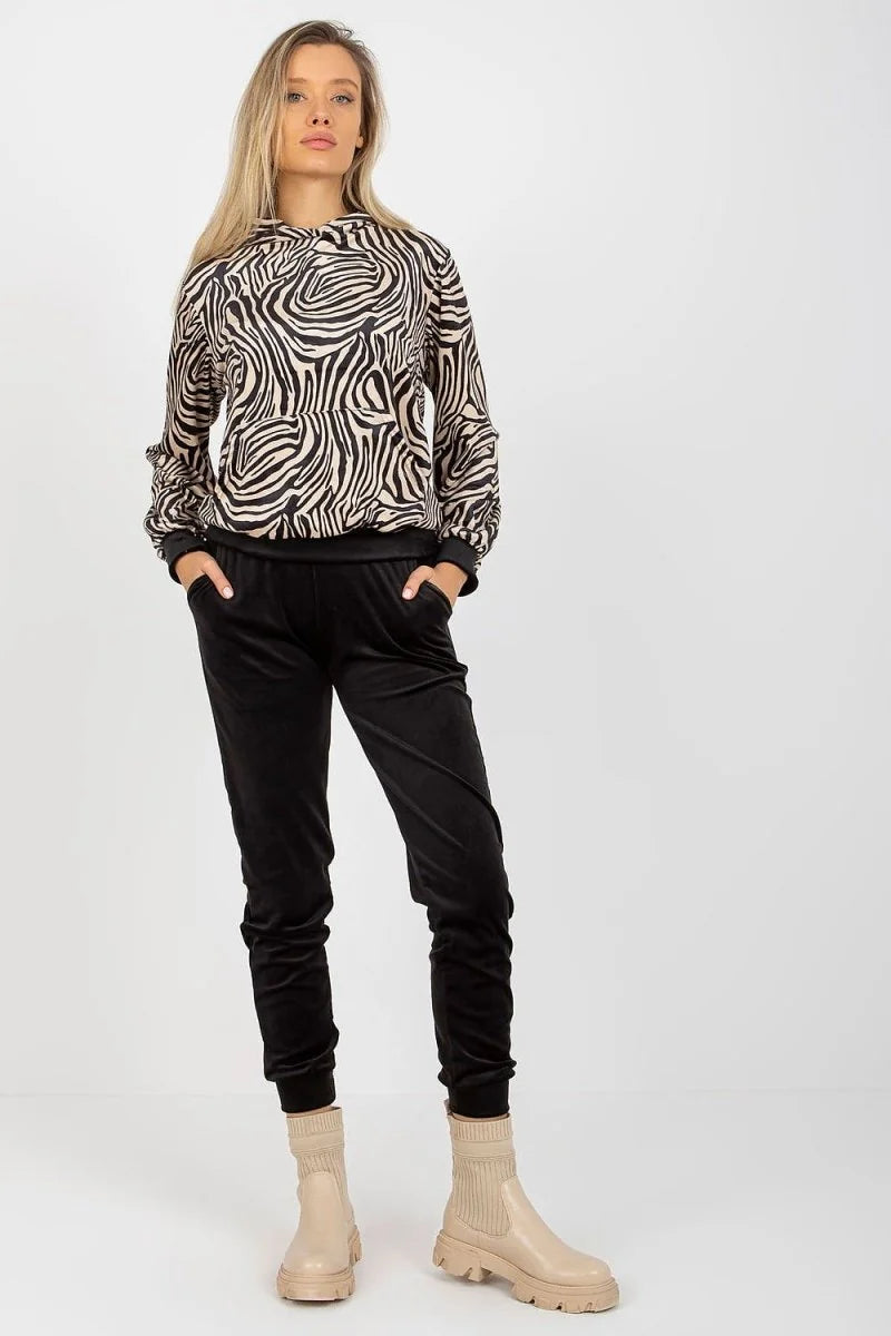 Black velvet jogger pants with a zebra print hooded sweatshirt and beige boots on a model.