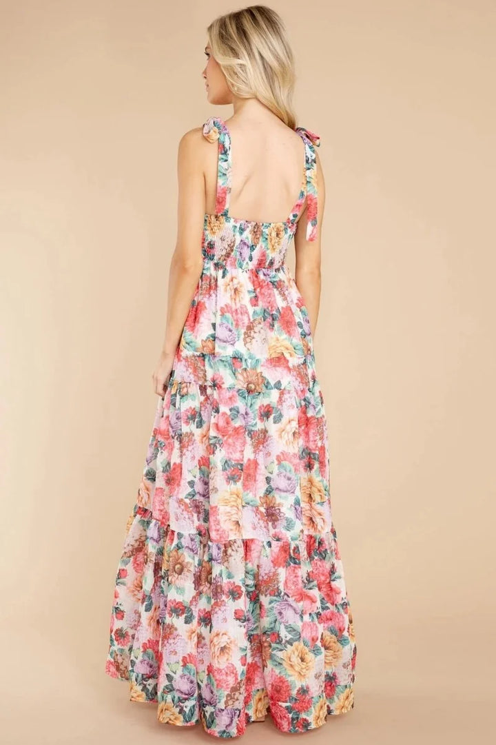 Maxi dress with floral print, featuring smocked bodice and tiered skirt with tie shoulders.