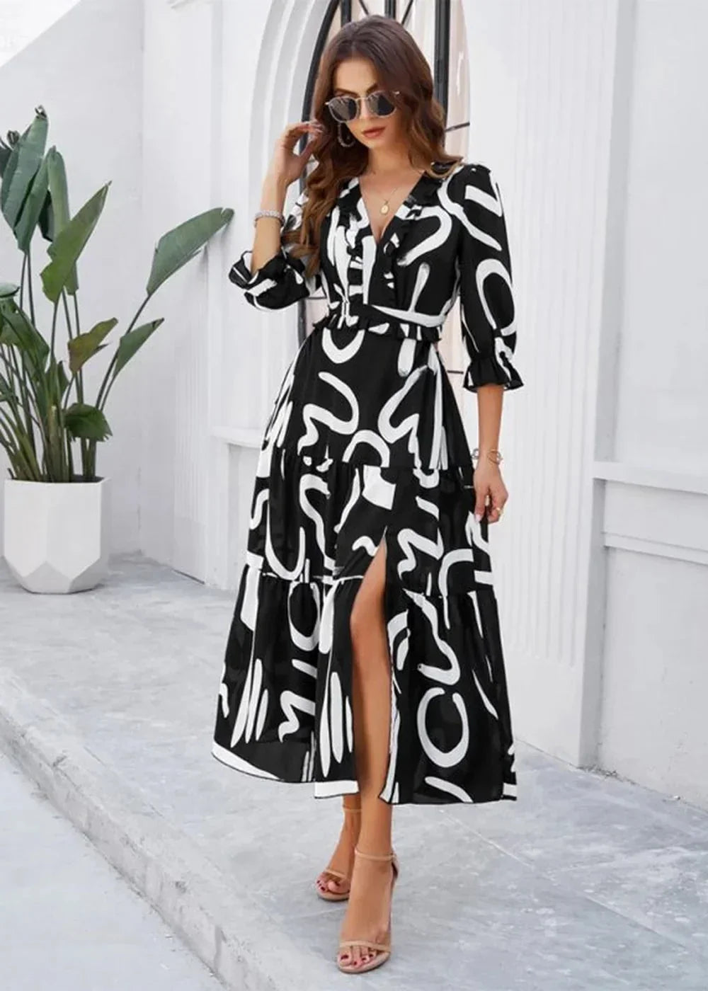 Black and white abstract print maxi dress with a ruffled V-neck, cinched waist, and a high slit, on model.